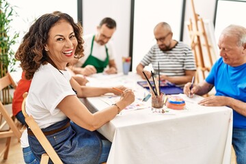 Sticker - Group of middle age draw students sitting on the table drawing at art studio. Woman smiling happy looking to the camera.