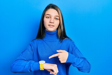 Poster - Young brunette girl wearing turtleneck sweater in hurry pointing to watch time, impatience, upset and angry for deadline delay