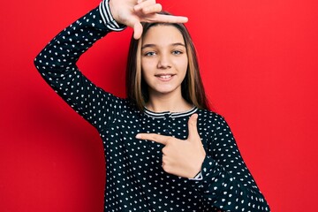 Poster - Young brunette girl wearing casual sweater smiling making frame with hands and fingers with happy face. creativity and photography concept.