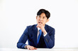 © 이 상신 - 흰 배경 앞에 정장 입은 고민하는 30대 한국 남자