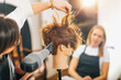 © Microgen - Hairdresser with the Hair Dryer in Hands Teaching Students How to do Hairstyling