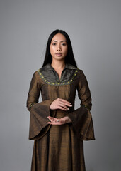 Poster - Close up  portrait of beautiful young asian woman with long hair wearing medieval fantasy gown. Graceful  pose with gestural hands,  isolated on studio background.