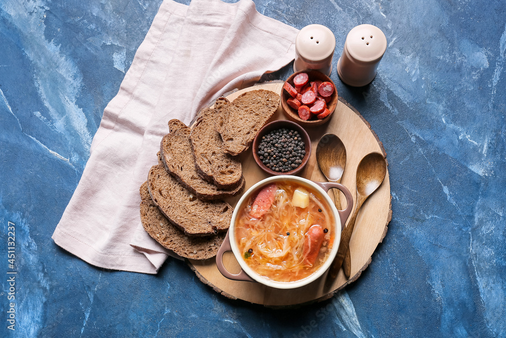 Composition with tasty sauerkraut soup on color background