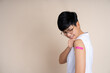 © PBXStudio - Asian people showing arm with pink bandage after receiving vaccination
