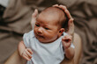 © Ananass - close up portrait of a beautiful baby in the arms of mom in the bedroom in daylight