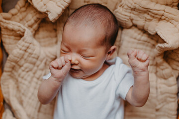 portrait of a cute newborn baby who just woke up, bubbling and stretching