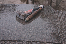 Sculptor Tools On A Granite Slab, Close Up. Workplace, Traditional Tools Sculptor, Hammer And Chisel For Working Stone. Latvia. Stone Is From Sweden, Its Name Champagne Bjarlov, Wet Surface After Rain