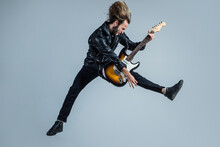 Emotional Bearded Rock Musician Playing Electric Guitar In Leather Jacket And Jumping, Guitar Player