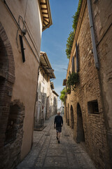 A young man walk along the beautiful streets of Spello, Umbria