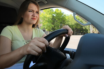 Wall Mural - Emotional woman in car. Aggressive driving behavior