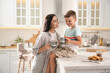 © New Africa - Happy mother and son having breakfast together in kitchen. Adoption concept