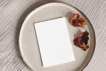 Wall Mural - autumn composition. blank greeting card mockup and dry beech leaves on ceramic plate. beige muslin t