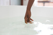 © Wavebreak Media - Close up of hand of african american woman in bathroom touching water in bath