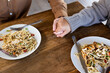 © Wavebreak Media - Close up of happy diverse couple in living room eating dinner together holding hands