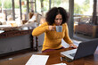 © Wavebreak Media - Mixed race woman sitting at table and working remotely using laptop