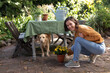 © Wavebreak Media - Portrait of smiling caucasian woman in garden with her pet dog, gardening
