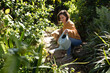 © Wavebreak Media - Smiling caucasian woman in garden with her pet dog, gardening
