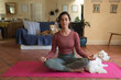 © Wavebreak Media - Caucasian woman in living room with her pet dogs, practicing yoga, meditating