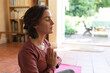 © Wavebreak Media - Caucasian woman in living room, practicing yoga, meditating