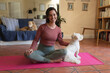 © Wavebreak Media - Portrait of smiling caucasian woman in living room with her pet dogs, practicing yoga