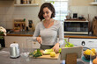 © Wavebreak Media - Caucasian woman in kitchen, preparing health drink, chopping vegetables