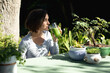 © Wavebreak Media - Caucasian woman in garden, sitting at table drinking health drink