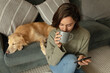 © Wavebreak Media - Caucasian woman in living room with her pet dog, using smartphone and drinking coffee