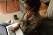 © Wavebreak Media - Caucasian woman in living room with her pet dog, sitting on floor, working using laptop