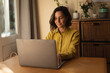 © Wavebreak Media - Caucasian woman in living room sitting at table, working using laptop