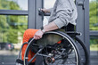 © Yakobchuk Olena - Physically challenged girl moving herself at the wheelchair and opening doors
