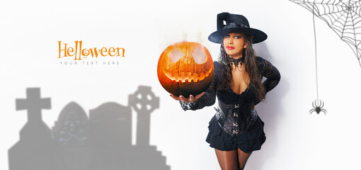 Wall Mural - Halloween Sexy Girl wearing witch costume mit einem helloween Kürbis with a hat. Party, Celebrating. Beauty Woman with long red hair and holiday bright make-up isolated on white background.