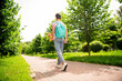 © deagreez - Full length body size rear back behind view of attractive girl walking street carrying skate on fresh air outdoors