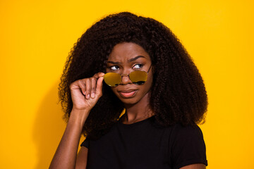 Sticker - Photo portrait unhappy suspicious woman looking copyspace taking off sunglass isolated vibrant yellow color background