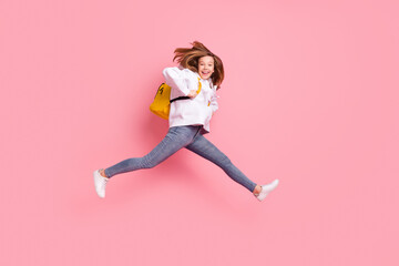 Wall Mural - Full length body size girl jumping up wearing yellow rucksack isolated pastel pink color background