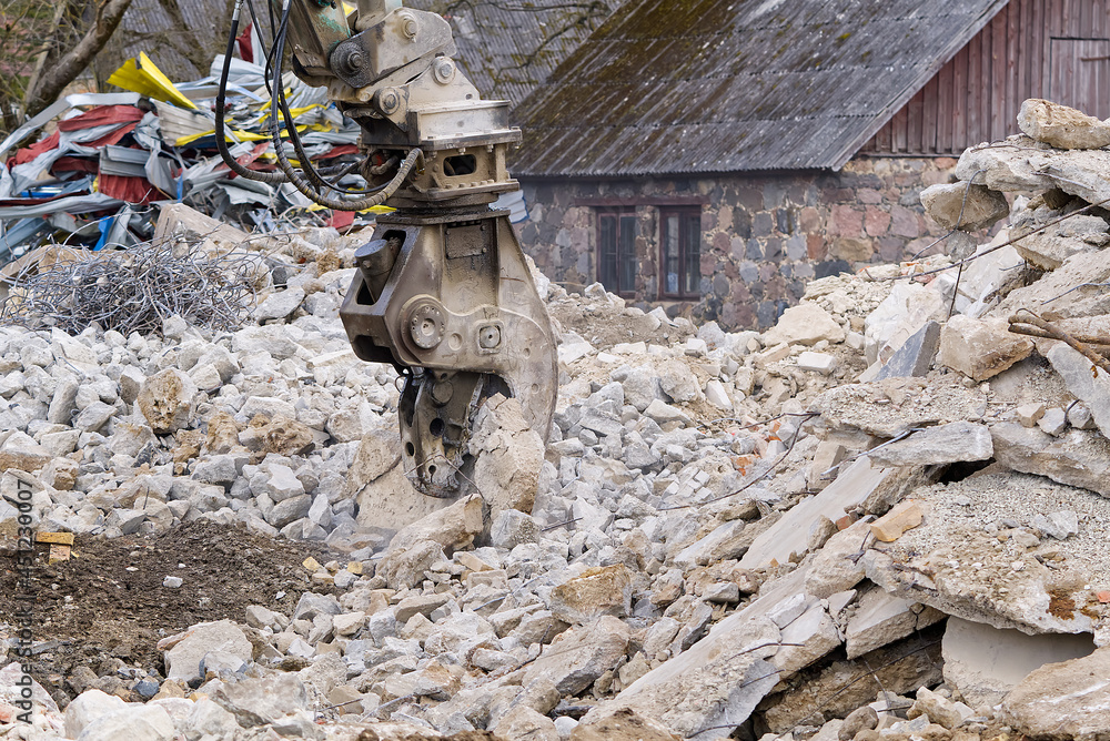 Old stone building demolition with excavator. Excavator working on ...