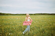 © ADDICTIVE STOCK - Unrecognizable carefree woman walking in blooming field