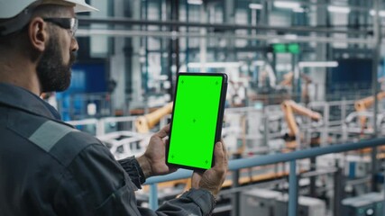 Fototapete - Car Factory Engineer in Work Uniform Using Tablet Computer with Green Screen Mockup Display. Augmented Reality Software at Automotive Industrial Manufacturing Facility Working on Vehicle Production.