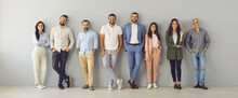 People In Modern Business. Portrait Of A Team Consisting Of Men And Women Of Different Ages Standing In A Row Near The Wall. Happy Smiling People Who Are Determined To Succeed And Achieve Results.