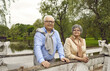 © Studio Romantic - Portrait of happy loving retired couple relaxing standing on old stone bridge enjoy rest in city public park. Weekend vacation or travel adventure on retirement. Healthy lifestyle for pensioner