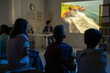 © pressmaster - Group of schoolkids watching video about natural environment in dark classroom