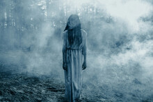 Girl In Image Of Scary Zombie Walks In Dark Forest Among Smoke.
