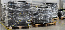 High pressure hydraulic hoses on a pallet, packed in transparent polyethylene film. Packaged high pressure hydraulic hoses and ready for transport. Warehouse with hydraulic hoses.