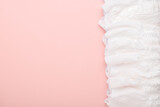 Fototapeta Dinusie - A large stack of disposable diaper panties on a pink background with a place to copy. top view, a place to copy.