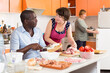 © JackF - Two European women and African American man cooking together at kitchen