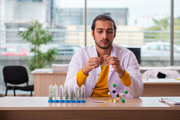 Young male chemist in drug synthesis concept