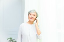 Senior Asian Woman Holding Cell Phone Using Mobile Online Apps.