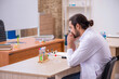 © Elnur - Young male chemist sitting at the desk in the classroom