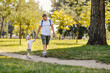 © Dusan Petkovic - Happy childhood. Father and son walking through the woods on a sunny summer day. Dad holds his son's hand and they walk. A walk in the park with the family on a sunny summer day. Matching clothes