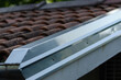 Building: cornice with galvanized steel sheet, detail of the house on the part of the double-sided roof with ridge tiles. roof flashing,
