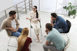© New Africa - Psychotherapist working with group of drug addicted people at therapy session indoors